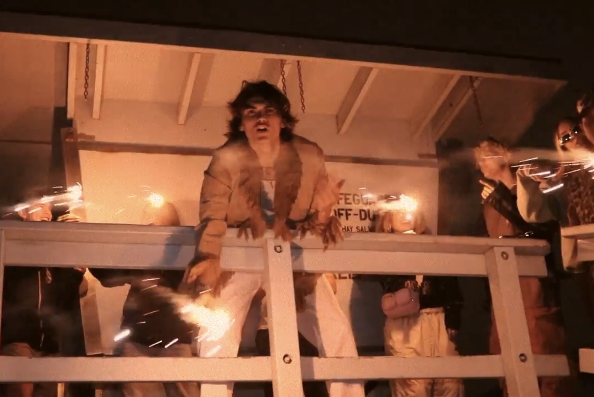 SLOWDOWN music video still, balcony scene with sparklers